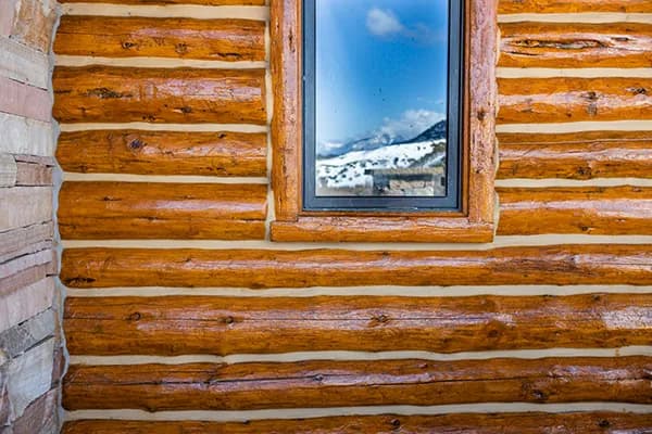 Side-by-side comparison of traditional chinking versus modern weather sealing techniques for log cabin maintenance