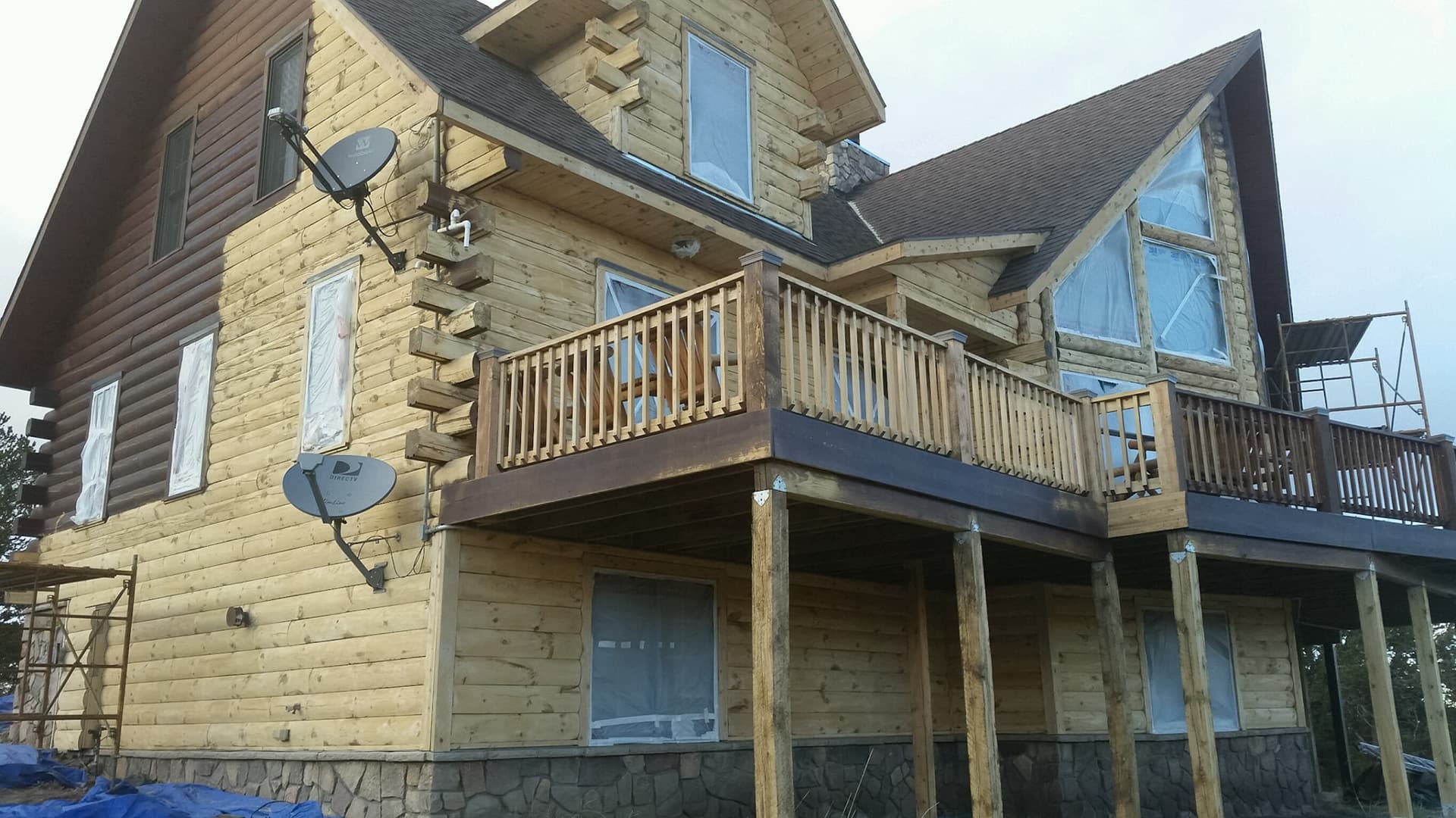 Before and after media blasting comparison showing old stain removal process on Colorado log home using corn cob and walnut shell blasting techniques for complete restoration