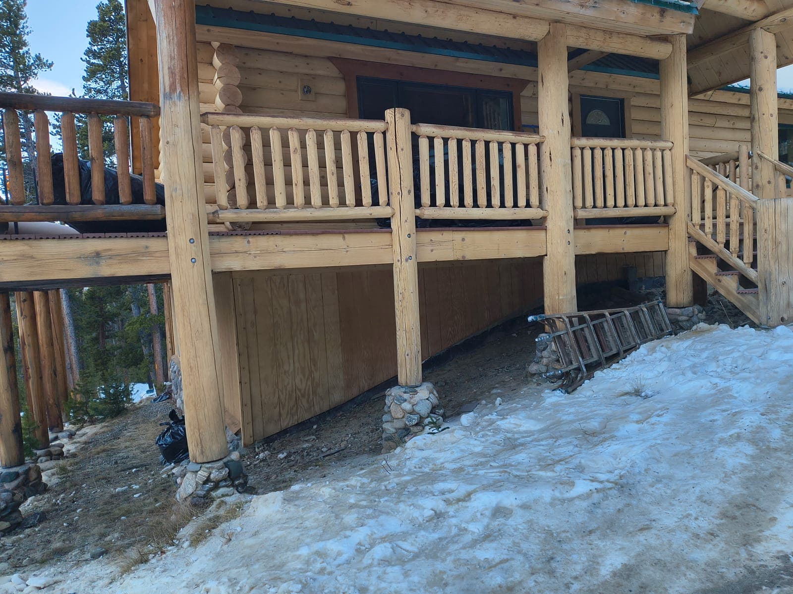 Log home exterior showing complete railing system with deck support posts and stairs in Colorado mountains